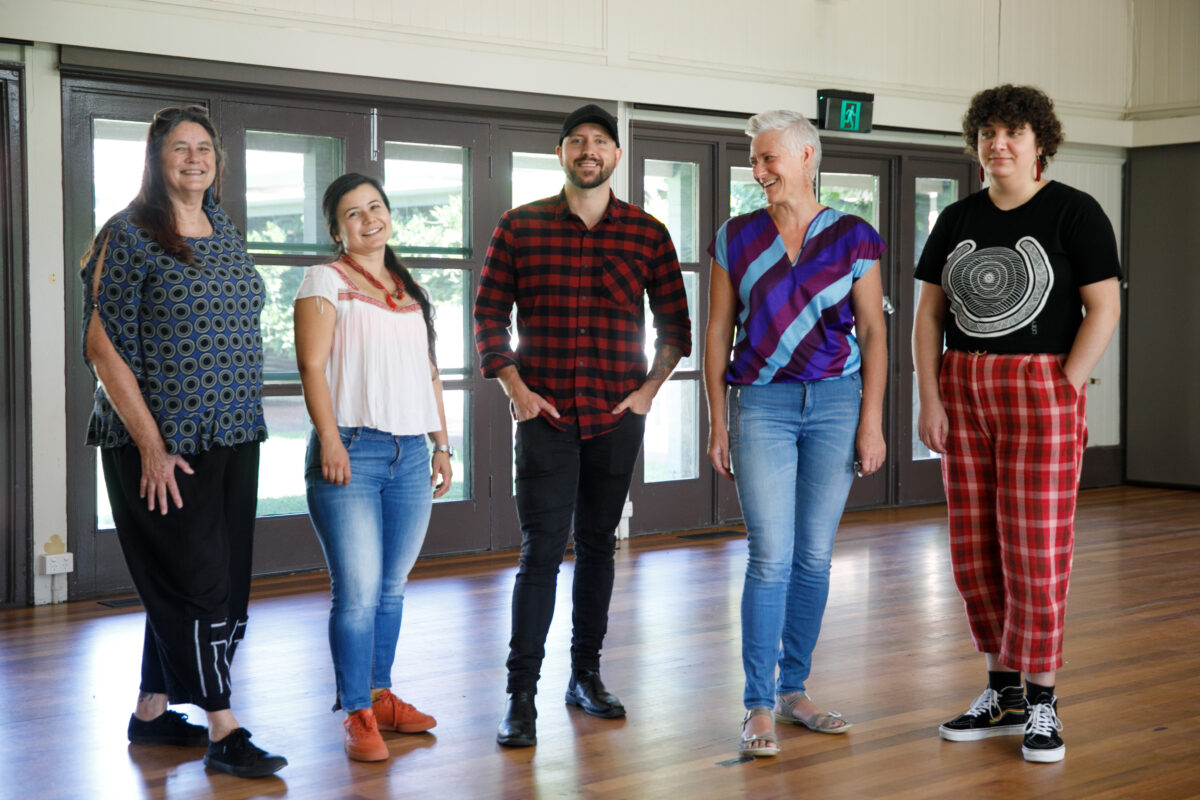 Five people standing in a line looking at the camera havin' a good time