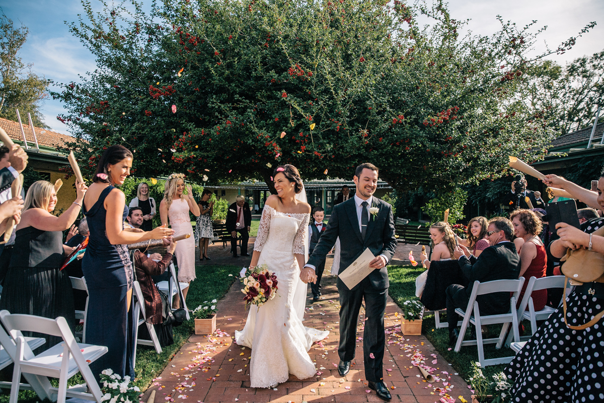 Intimate wedding ceremony with flower petals in a courtyard.