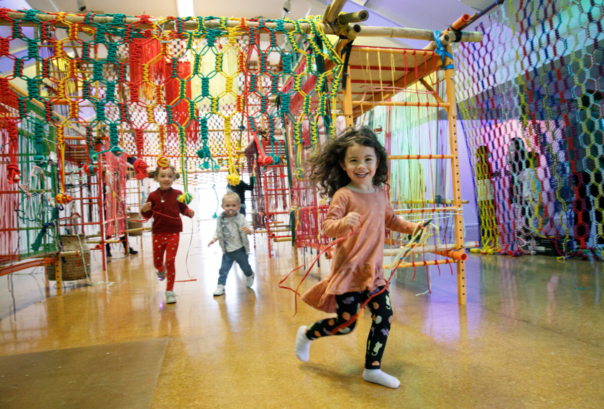 A child running through artwork by Slow Art Collective