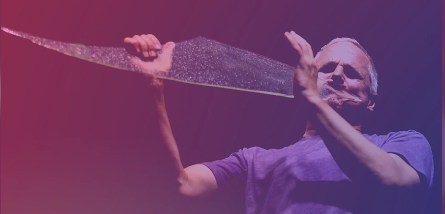 A man with a shard of glass to his face - intending to play it with contact mics