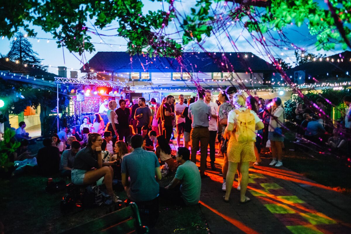A group of people standing in the Gorman Courtyard having fun chatting and drinking