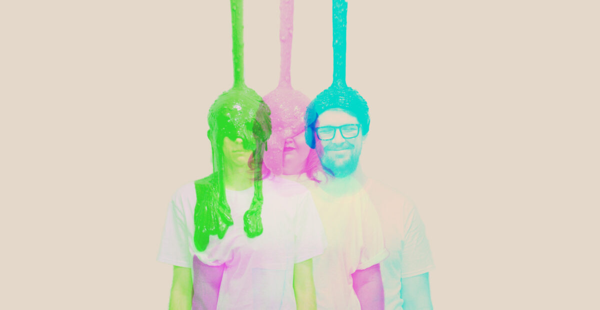 Three overlapping portraits of the band members that are slightly offset. They are each photographed in single colours, green on the left, pink in the middle and light blue on the right.