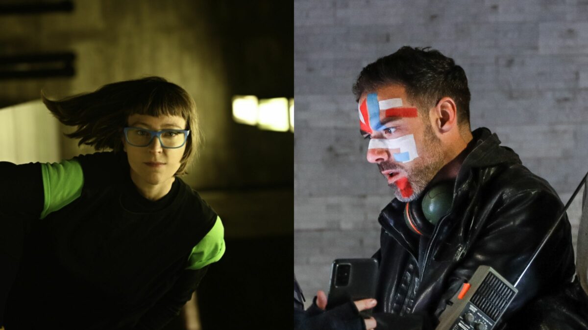 On the left side of the frame a woman is standing in a dimly lit underpass, on the right a man with red, blue and white stripes painted on his face.