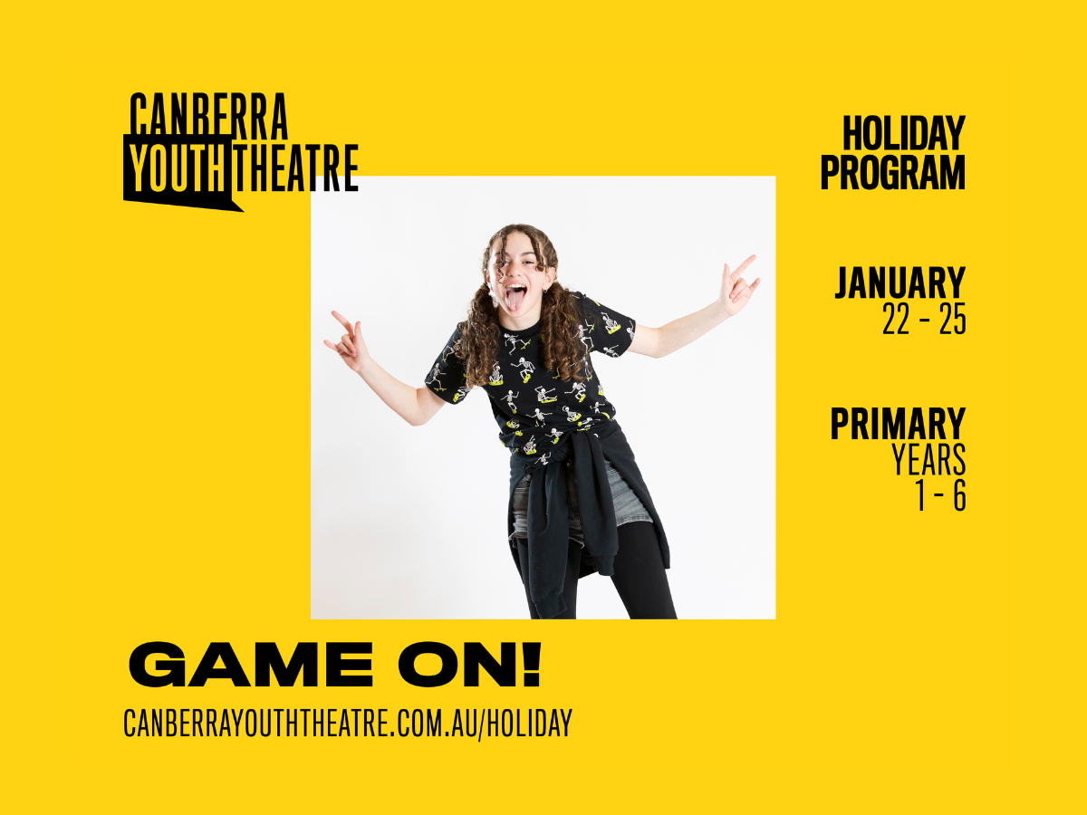 Teen girl poses inside a yellow from with writing and logos around it.